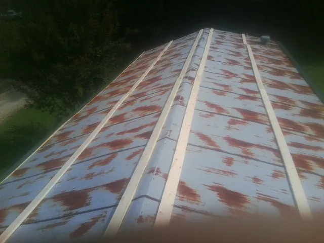 Rusted metal roof panels with new wood purlins before replacement — Storm Damage Roof Repair in Oyens by Roofing Brothers