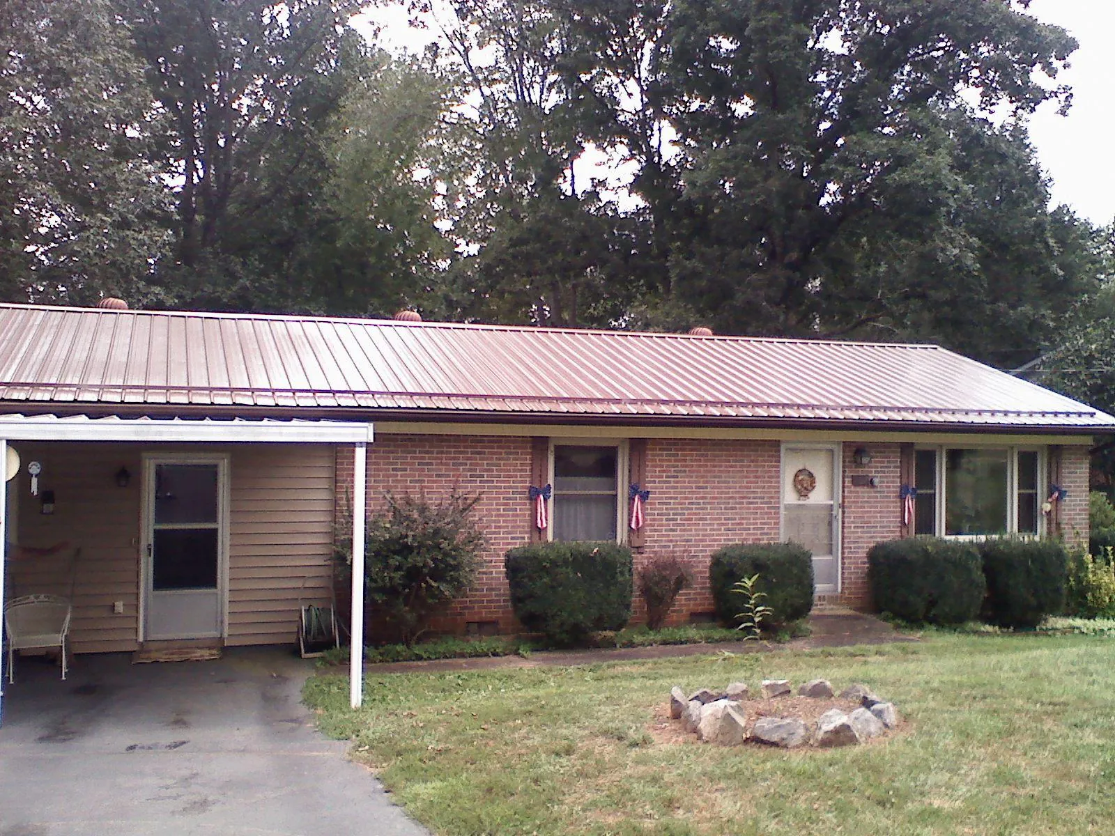 Bronze metal roof and carport on a brick ranch home — Roof Repair work by our crew in Oyens