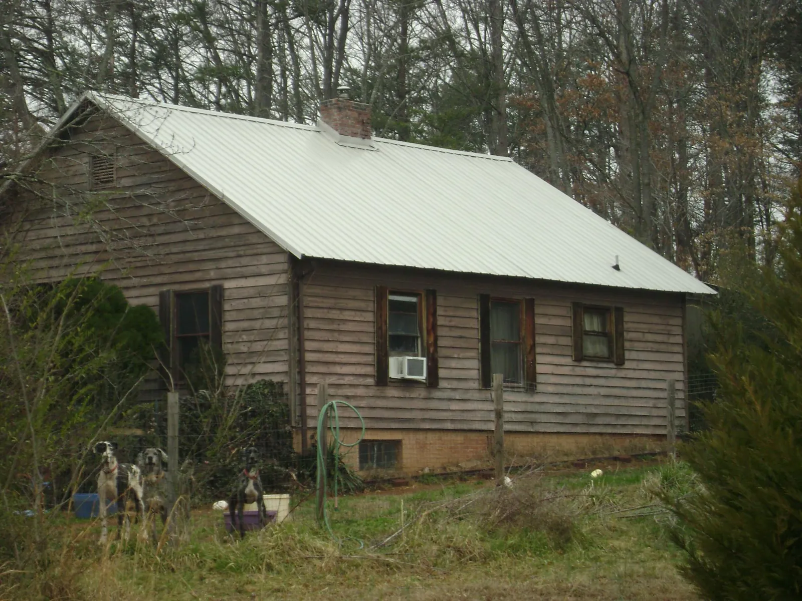 White metal roof on an old wood sided farmhouse, from a Metal Roof Installation job in Oyens